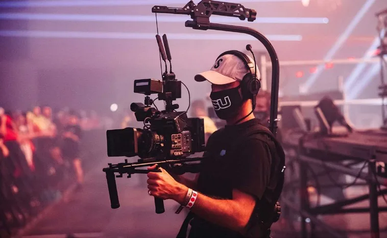 Videographer operating a camera rig during event coverage